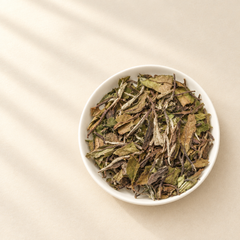 White Peony Aged 6 Years dry tea leaves in white ceramic dish